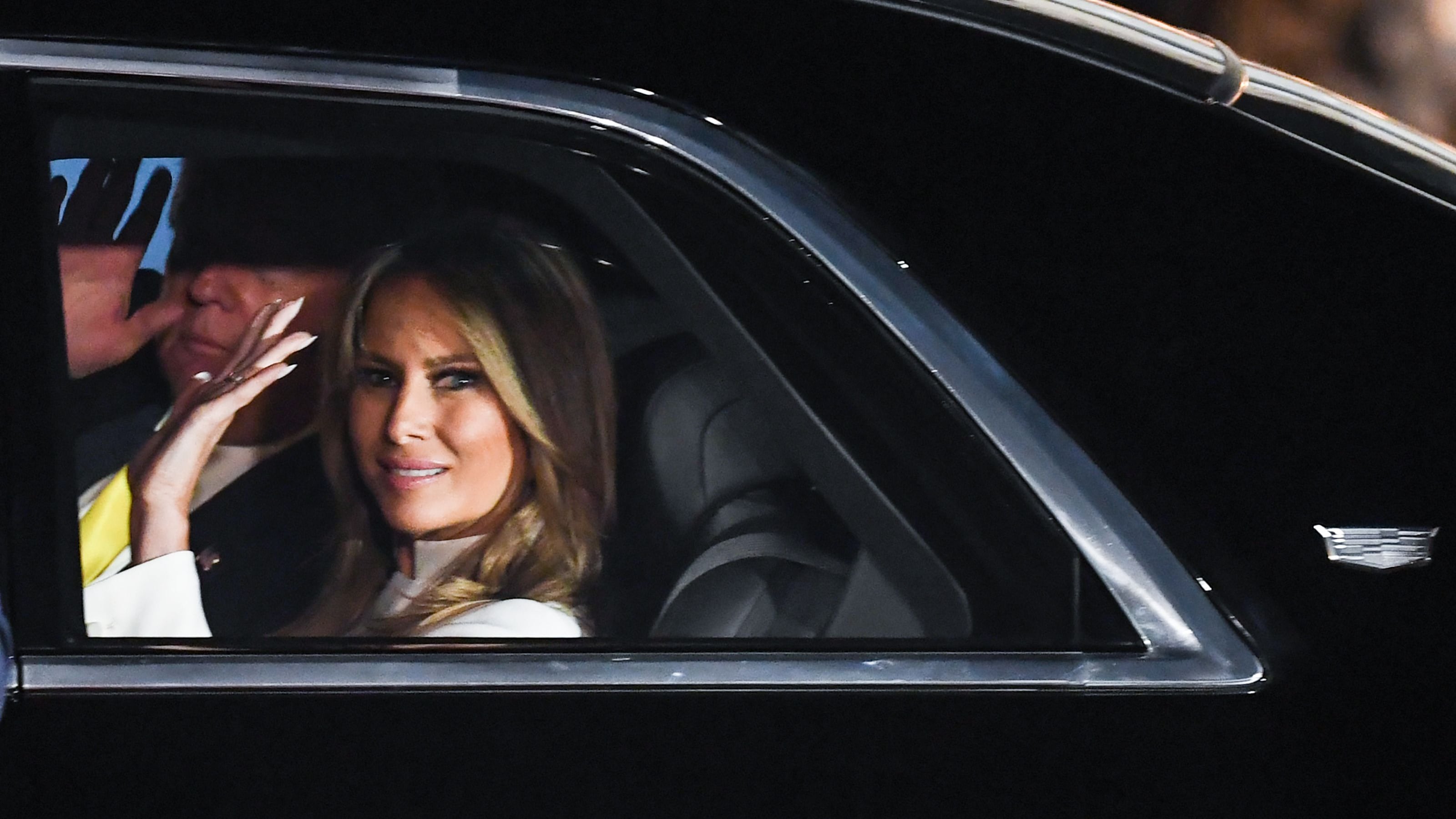 US President Donald Trump and First Lady Melania Trump wave from their car as they leave Palam Air Force Base in New Delhi on February 24, 2020