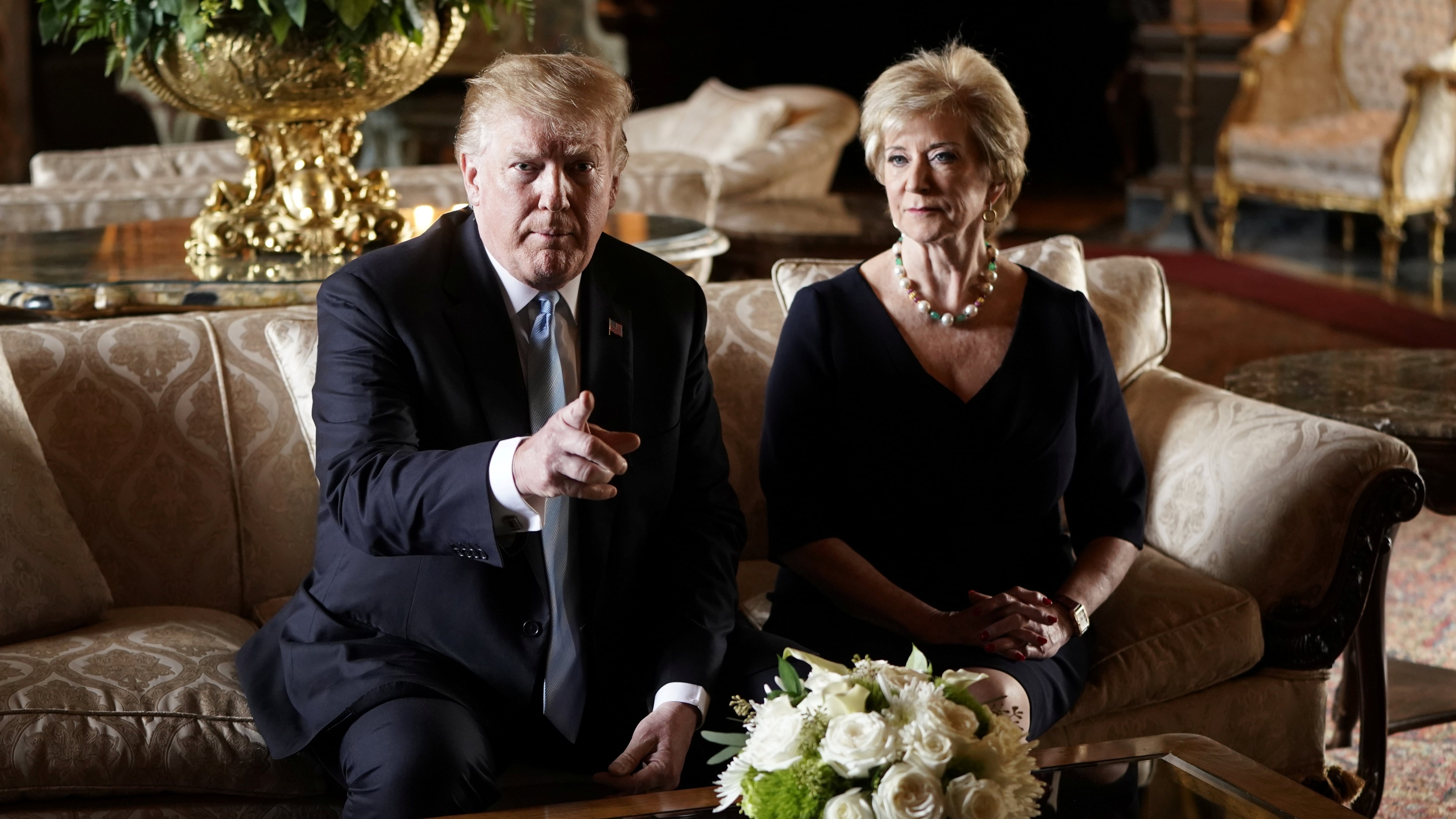 U.S. President Donald Trump talks to reporters about the resignation of Linda McMahon, Administrator of the Small Business Administration, as she sits beside him at Trump's Mar-a-Lago estate.