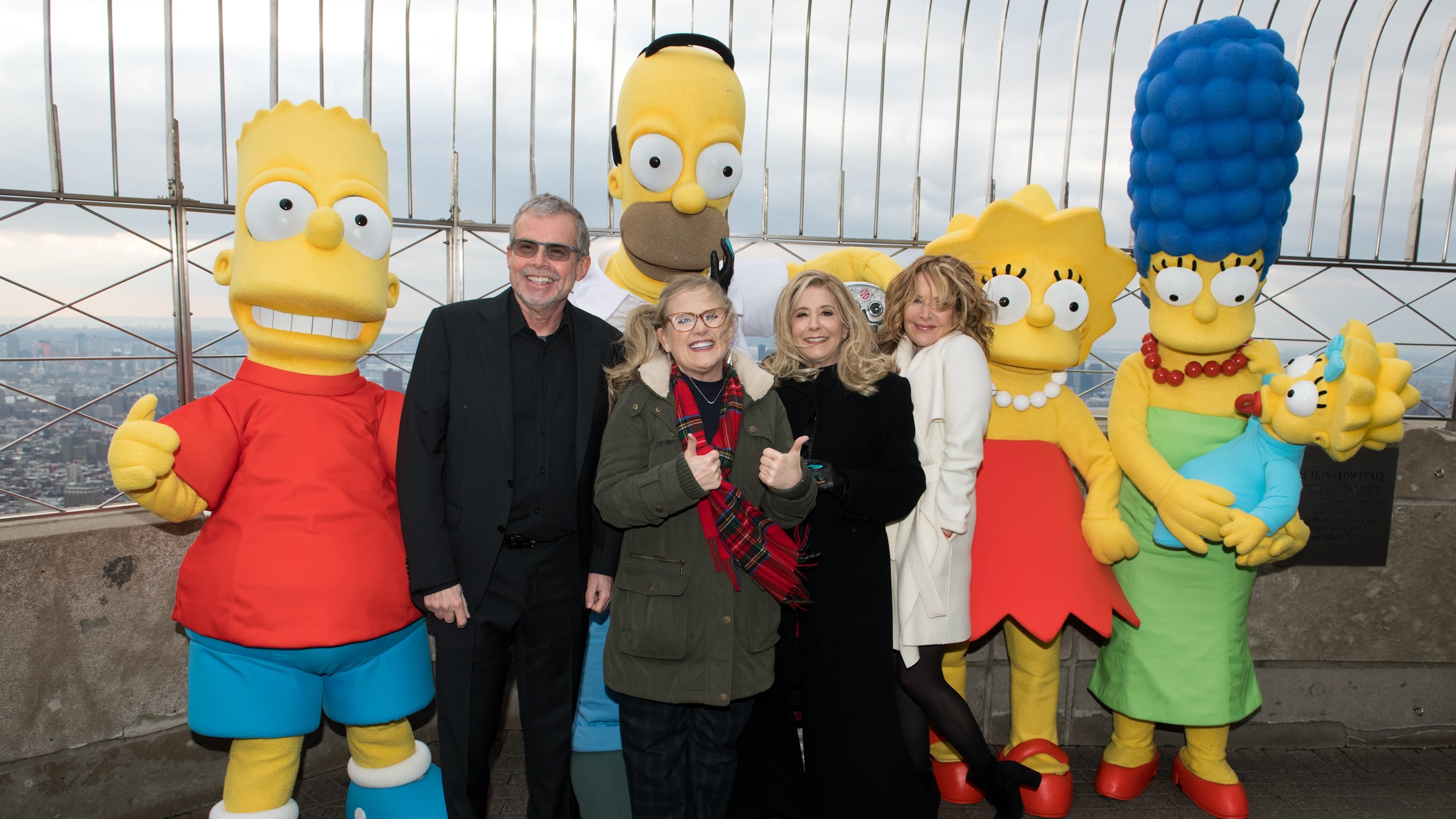 NEW YORK, NY - DECEMBER 17:  (L-R) Bart Simpson, Mike Scully, Homer Simpson, Nancy Cartwright, Pamela Hayden,  Stephanie Gillis, Lisa Simpson, Marge Simpson and Maggie Simpson visit The Empire State Building to celebrate the 30th anniversary of "The Simpsons" at The Empire State Building on December 17, 2018 in New York City.  (Photo by Noam Galai/Getty Images)