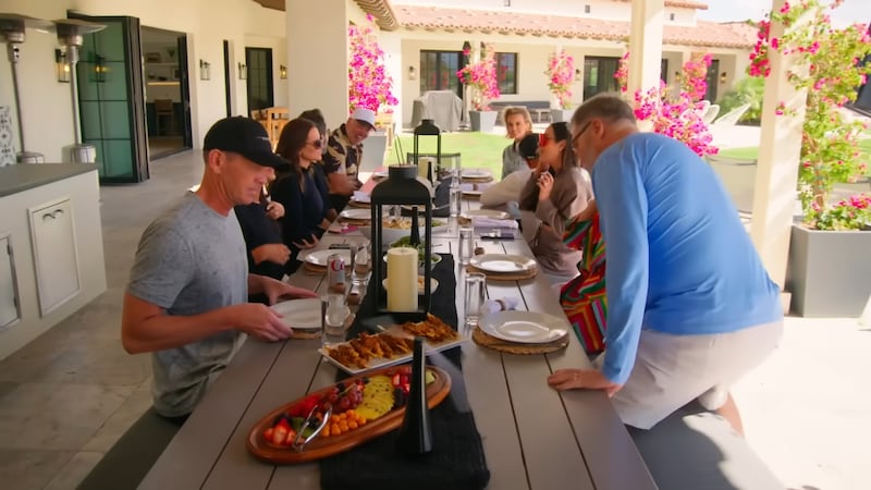 The couples sit down to eat and argue.